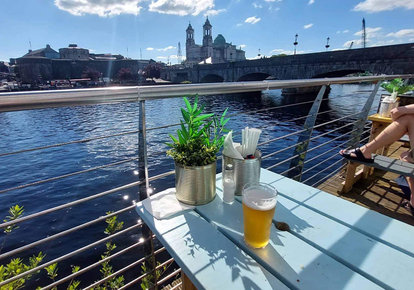 Outdoor tables beside the river Shannon at Dead Centre Brewing.